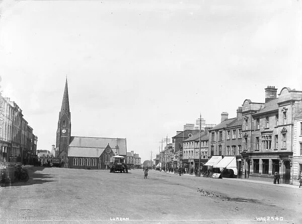 Lurgan - a street scene with motor bus and people and shop fronts and church