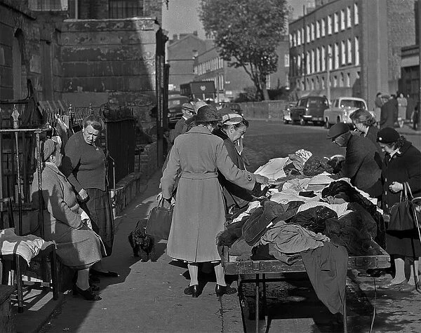 Sifting through old clothes at a market, London