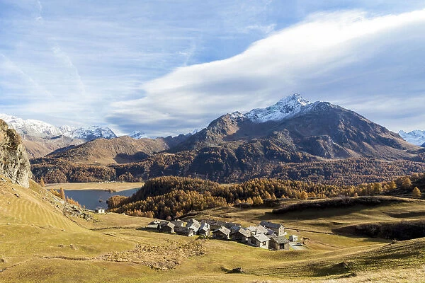 Huts and Lake Sils framed by the colorful woods in autumn Grevasalvas Upper Engadine
