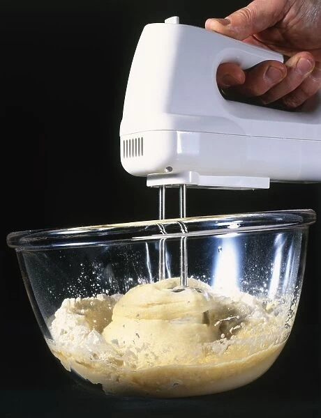 Mixing butter, egg, sugar and flour with electric hand mixer, close-up