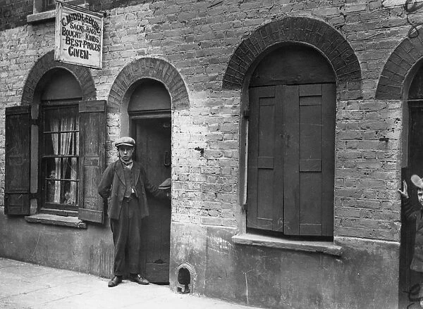Bag Man. circa 1900: A youth standing outside C Middleburgs sacks