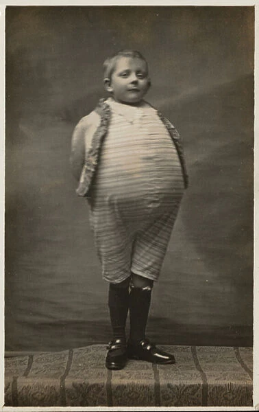 School boy, dressed up to have a very large stomach (b  /  w photo)