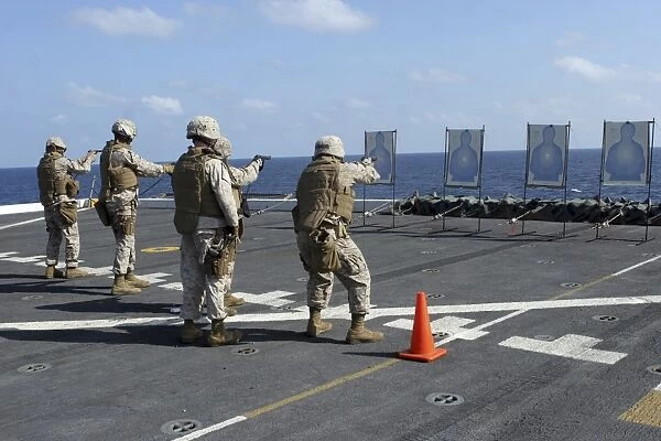 Military policemen train with the Berretta M9 9mm pistol aboard USS San Antonio