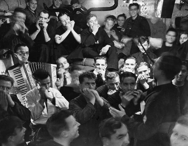 The crew of HMS Haarlem celebrate below decks after sinking a German U-boat Circa August