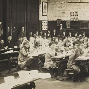Schoolchildren ear their midday meal at their desks. Date: early 20th century