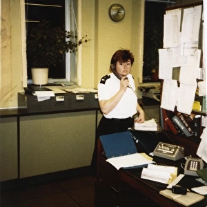 Woman police officer on the phone in a police station