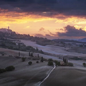 The classic countryside of the Val d Orcia, with Pienza on the hill, during an explosive autumn sunrise. Tuscany, Italy
