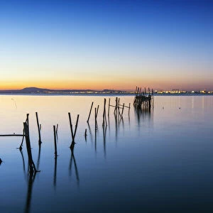 Wooden pillars pier, the palafite fishing harbour of Carrasqueira at dusk. Alcacer do Sal