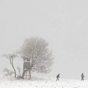 People walk through a snowy landscape near the village of Dorndorf-Steudnitz