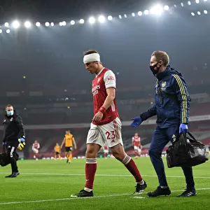 Arsenal's Empty Emirates: David Luiz Receives Treatment Alone Amidst Quiet Stadium Crowds (2020-21 Premier League: Arsenal vs. Wolverhampton Wanderers)