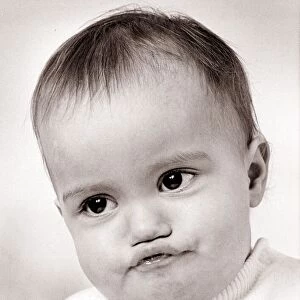 Baby boy with funny face expression, circa 1960