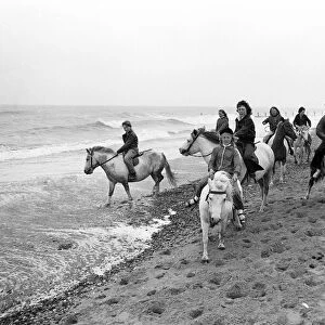 Children enjoying a seaside canter on the ponies despite the weather at Hornsea