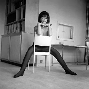 Jackie Collins authoress sitting astride a chair at home Mar 1964