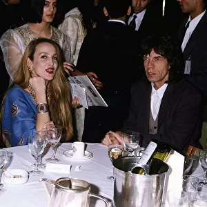 Mick Jagger Singer with wife Jerry Hall sitting at table a gala night