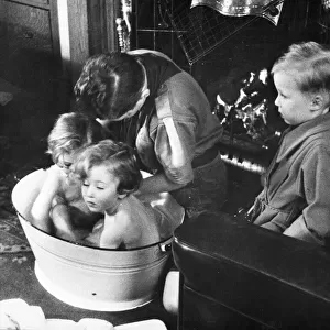 Picture shows a boy scout bathing a baby. Newcastle. Tyne and Wear