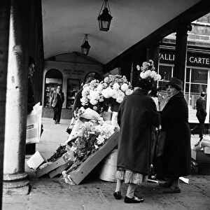 Women at a flower stall outside the Roman Baths, Bath, Somerset. 29th November 1964