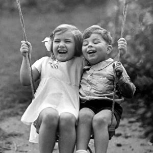 Young boy and girl playing together on the swing Circa 1945 P044435