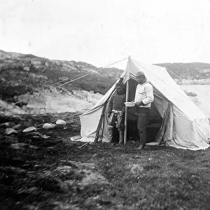 Portrait of an explorer together with a South-American woman, during the expedition to the Tierra del Fuego. They pose standing up in front of a tent